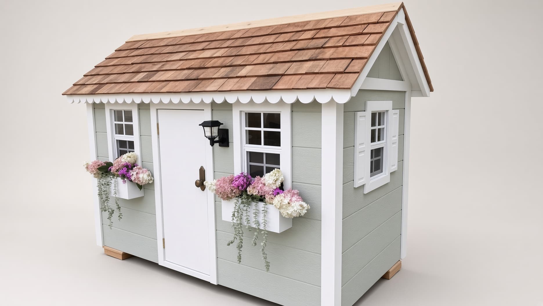 Three-quarter view of a Little Dream House with cedar shingle roof and hydrangea window boxes
